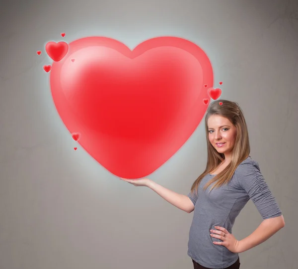 Young lady holding lovely 3d red heart — Stock Photo, Image