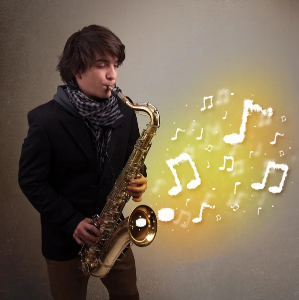 Guapo músico tocando en saxofón con notas musicales — Foto de Stock