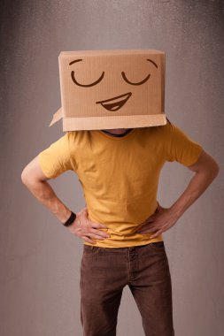 genç adam smiley ile kafasına bir karton kutu ile el hareketi