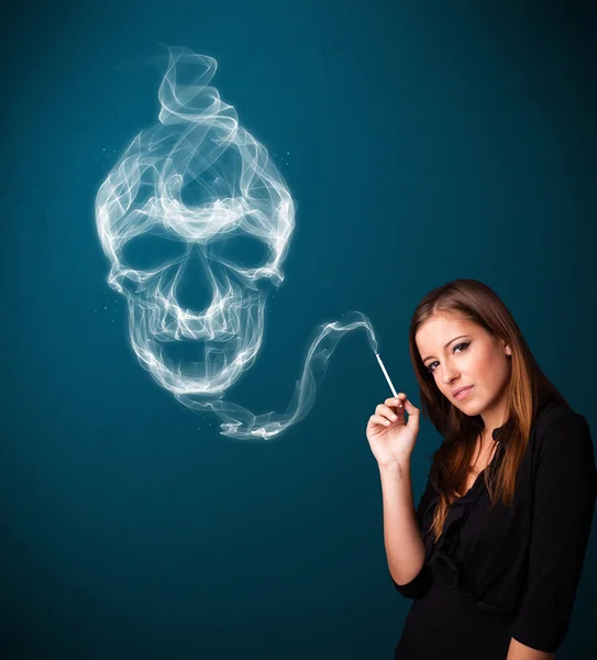 Mladá žena kouření nebezpečné cigarety s toxickým kouřem lebky — Stock fotografie