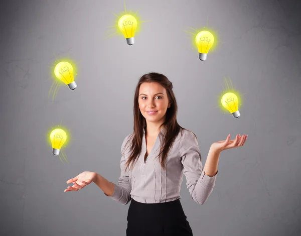 Young lady standing and juggling with light bulbs — Stock Photo, Image