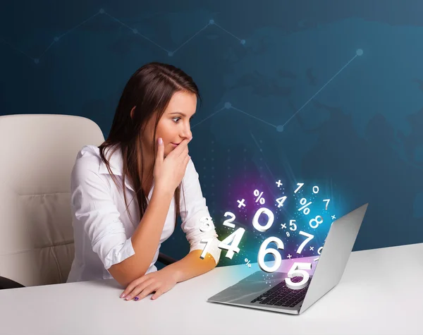Vacker ung kvinna sitter vid skrivbordet och skriva på laptop med — Stockfoto
