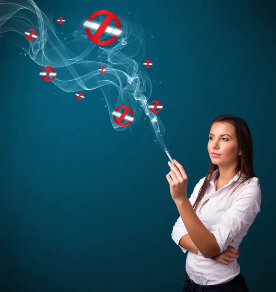 Young woman smoking dangerous cigarette with no smoking signs — Stock Photo, Image
