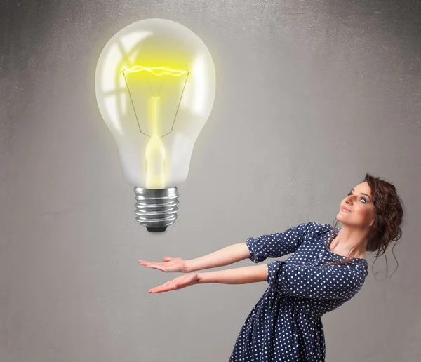 Beautiful lady holding realistic 3d light bulb — Stock Photo, Image