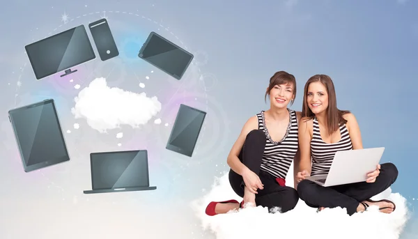 Young girls sitting on cloud enjoying cloud network service — Stock Photo, Image