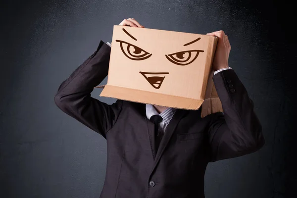 Empresário gesticulando com uma caixa de papelão na cabeça com o mal — Fotografia de Stock