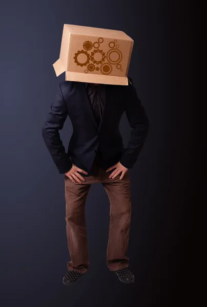 Junger Mann gestikuliert mit einem Karton auf dem Kopf mit Sporn — Stockfoto