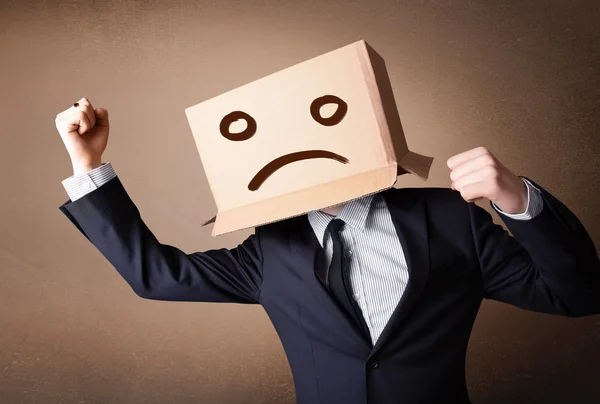 Businessman gesturing with cardboard box on his head with sad fa — Stock Photo, Image