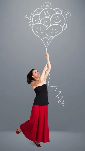 Mujer feliz sosteniendo globos sonrientes dibujo — Foto de Stock