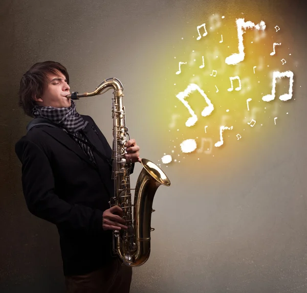Knappe muzikant die op saxofoon speelt met muzikale noten — Stockfoto