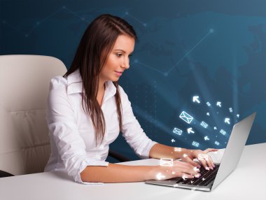 dest oturmuş ve ileti ICO ile laptop tipik genç bayan