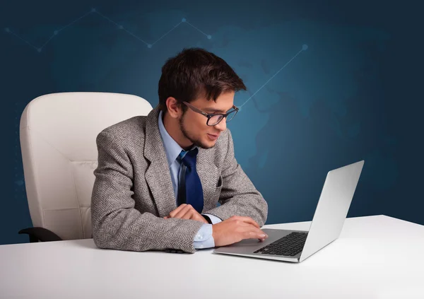 Νεαρός που κάθεται στο γραφείο και πληκτρολογεί σε φορητό υπολογιστή — Φωτογραφία Αρχείου