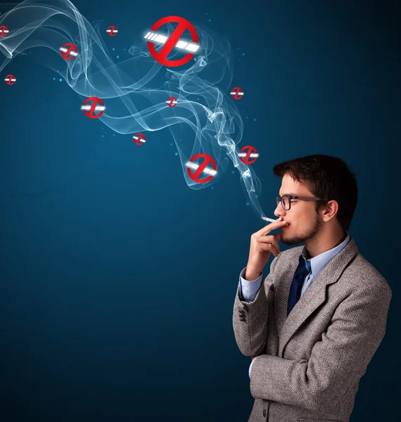 Attractive man smoking dangerous cigarette with no smoking signs — Stock Photo, Image