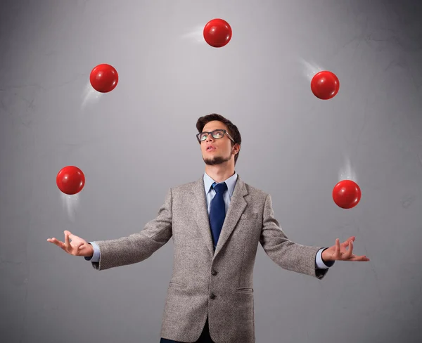 Jonge man permanent en jongleren met rode ballen — Stockfoto