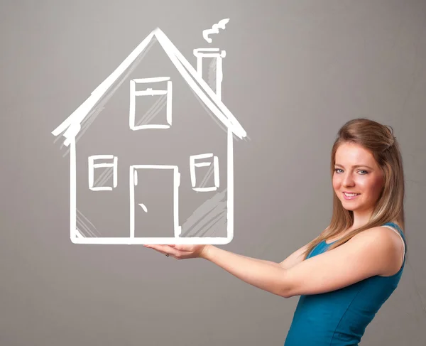 Young lady holding a huge drawn house — Stock Photo, Image