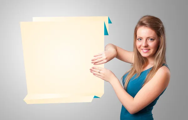 Mujer joven sosteniendo espacio de copia de papel de origami blanco — Foto de Stock