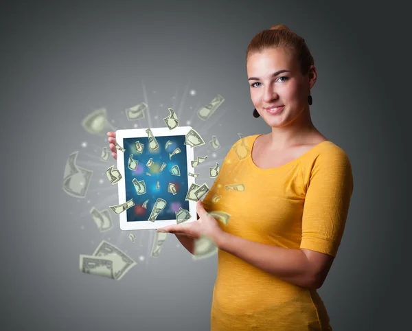 Jonge vrouw bedrijf tablet met geld — Stockfoto