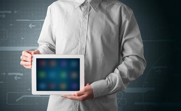Biznesmen trzymający białą nowoczesną tabletkę z rozmytymi aplikacjami — Zdjęcie stockowe