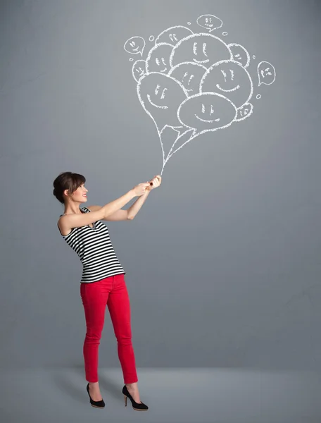 Happy woman holding smiling balloons drawing — Stock Photo, Image