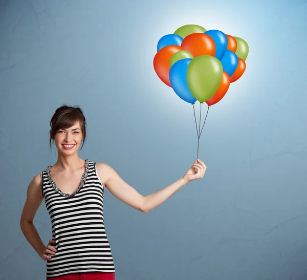 Genç bir kadın elinde renkli balonlar tutuyor. — Stok fotoğraf