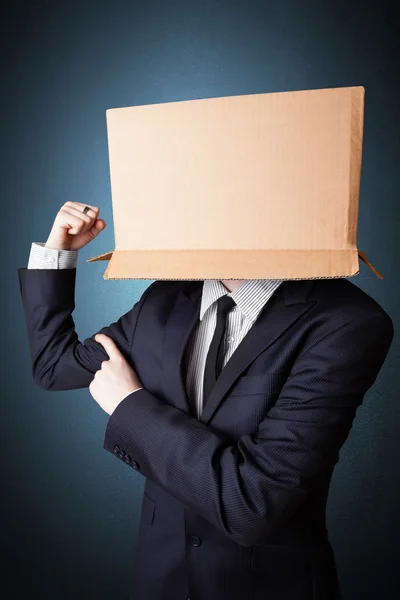 Businessman gesturing with a cardboard box on his head — Stock Photo, Image