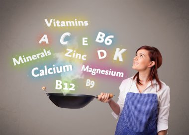 Genç bir kadın vitamin ve mineral pişiriyor.