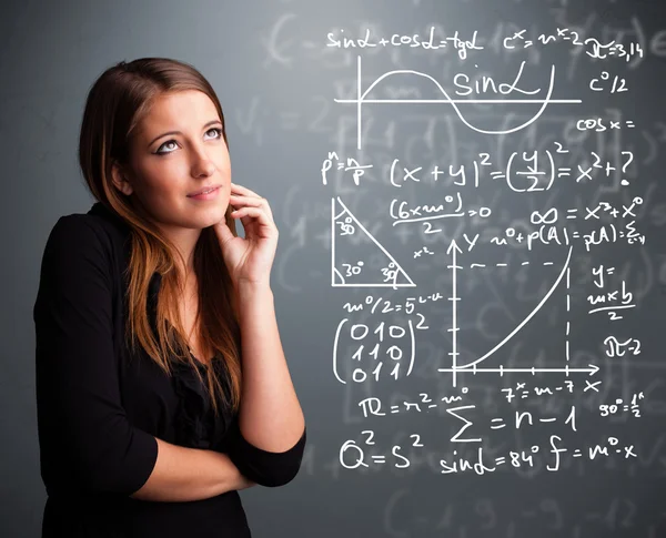 Vacker skolflicka tänker på komplexa matematiska tecken — Stockfoto