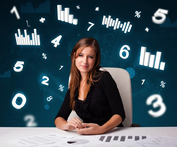 Jonge zakenvrouw aan het bureau met diagrammen en statistieken — Stockfoto