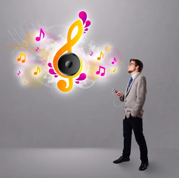 Jeune homme chantant et écoutant de la musique avec des notes musicales — Photo