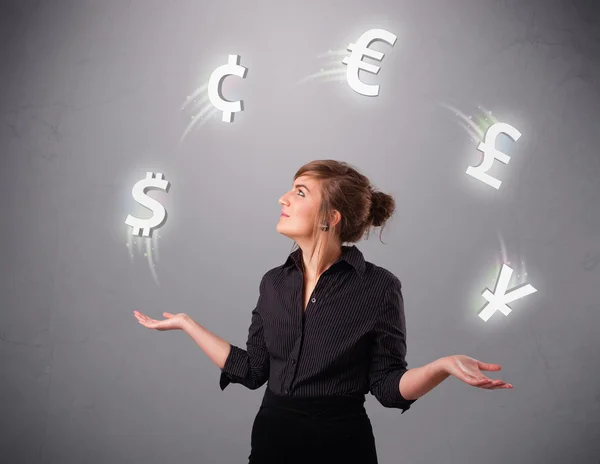 Young lady standing and juggling with currency icons — Stock Photo, Image