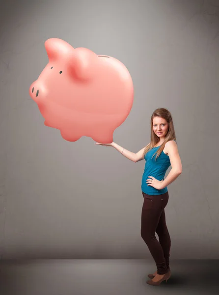 Young girl holding a huge savings piggy bank — Stock Photo, Image