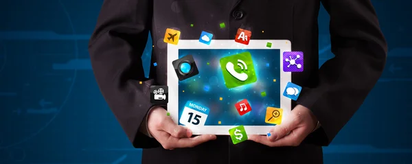 Podnikatel drží tablet s moderními barevnými aplikacemi a ikonami — Stock fotografie