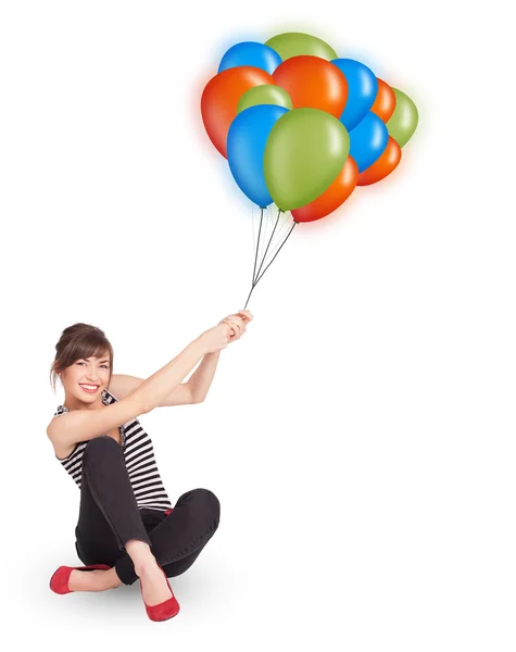 Genç bir kadın elinde renkli balonlar tutuyor. — Stok fotoğraf
