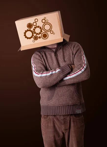 Young man gesturing with a cardboard box on his head with spur w — Stock Photo, Image