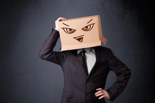 Businessman gesturing with a cardboard box on his head with evil — Stock Photo, Image