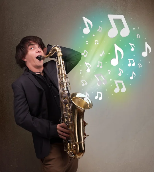 Young musician playing on saxophone while musical notes explodin — Stock Photo, Image