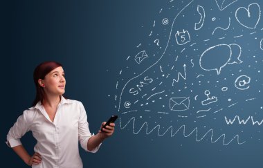 Çeşitli modern teknoloji simgeleriyle akıllı telefonda yazan kız
