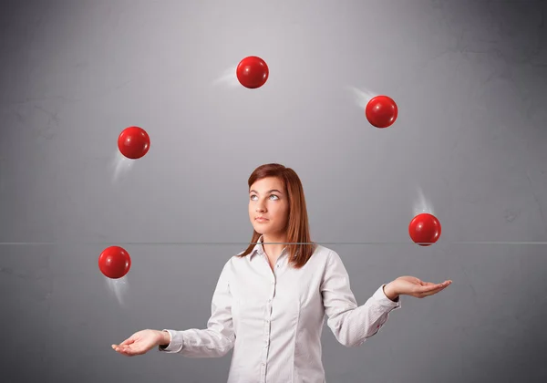 Jong meisje staan en jongleren met rode ballen — Stockfoto