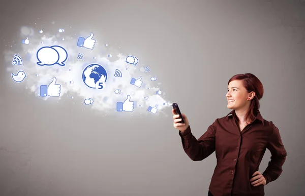 Pretty young girl holding a phone with social media icons — Stock Photo, Image