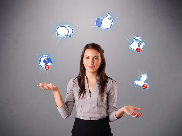 Приваблива молода жінка жонглює з іконками соціальної мережі — стокове фото