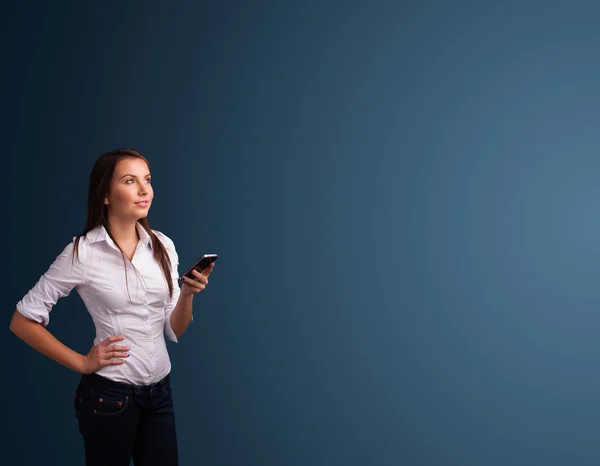 Jonge vrouw die op haar telefoon staat en typt met kopieerruimte — Stockfoto