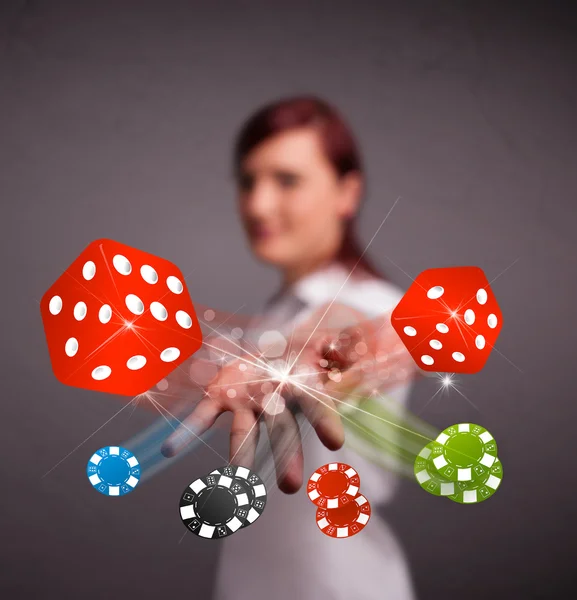 Young woman throwing dices and chips — Stock Photo, Image