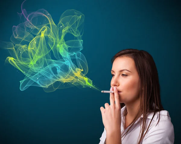 Pretty lady smoking cigarette with colorful smoke — Stock Photo, Image