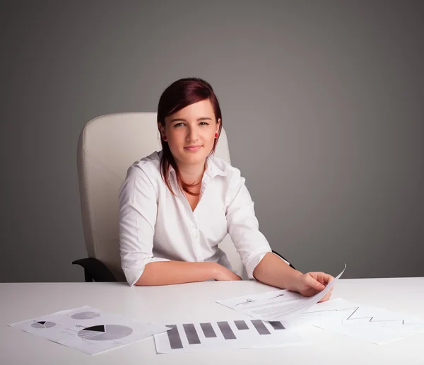 Bizneswoman siedzi przy biurku i wykonuje papierkową robotę — Zdjęcie stockowe