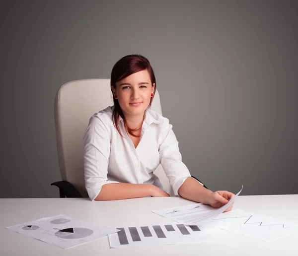 Zakenvrouw zit achter het bureau en doet papierwerk — Stockfoto