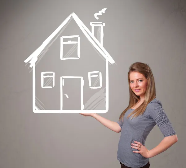 Young lady holding a huge drawn house — Stock Photo, Image