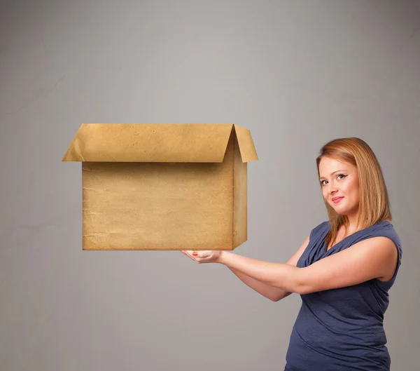 Jeune femme tenant une boîte en carton vide — Photo