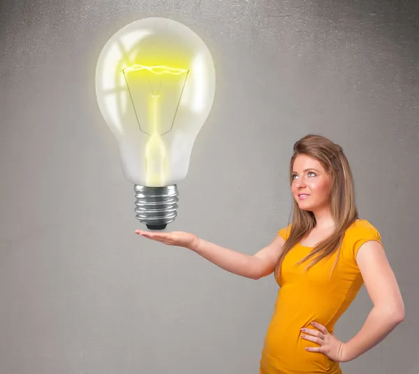 Beautiful lady holding realistic 3d light bulb — Stock Photo, Image