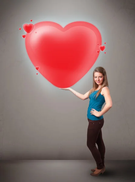 Young lady holding lovely 3d red heart — Stock Photo, Image