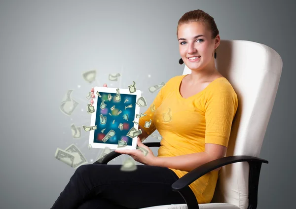 Молодая женщина держит планшет с деньгами — стоковое фото